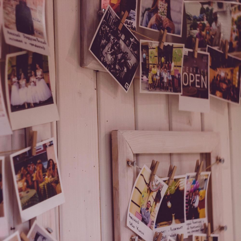 Charming display of nostalgic polaroid photos clipped to a rustic wooden frame, capturing memories and evoking warmth and sentimentality