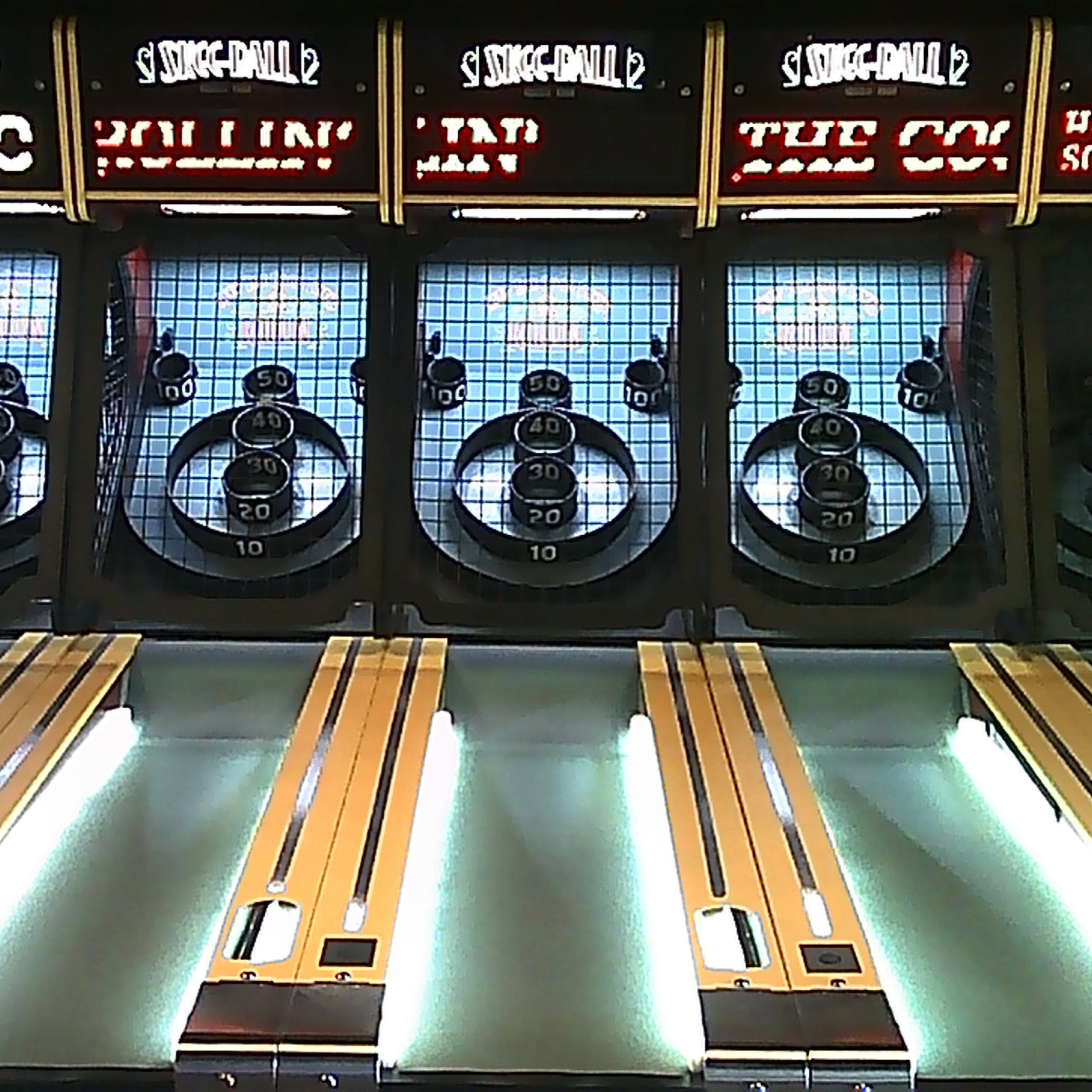 Classic skee-ball arcade game with illuminated lanes and nostalgic retro signage, evoking the charm of vintage gaming and family fun.