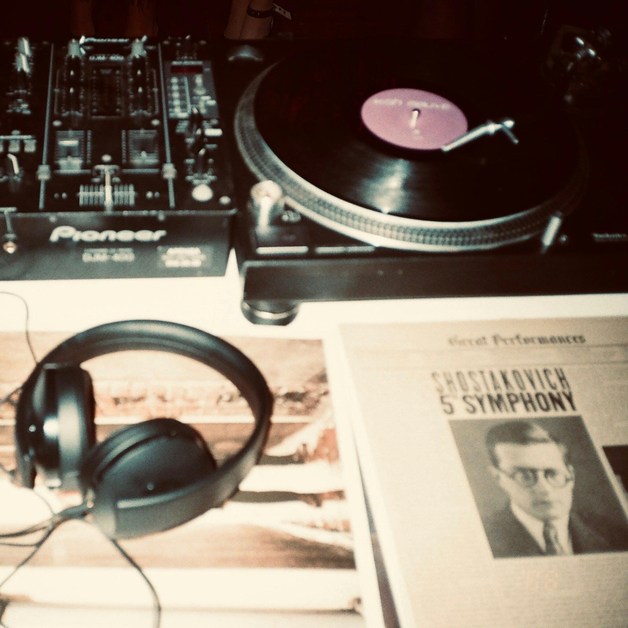 Retro-styled image featuring a turntable, a Pioneer mixer, headphones, and a vintage program for Shostakovich's 5th Symphony, blending music nostalgia with classic analog aesthetics.