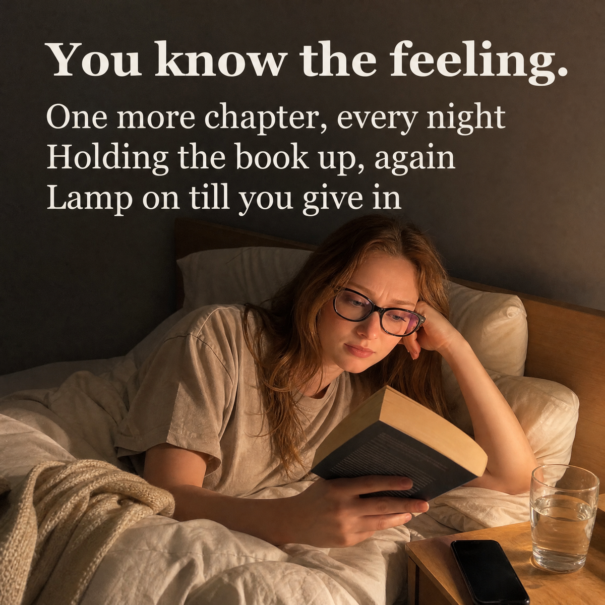 Woman reading in bed, propped on one elbow with the book held up
