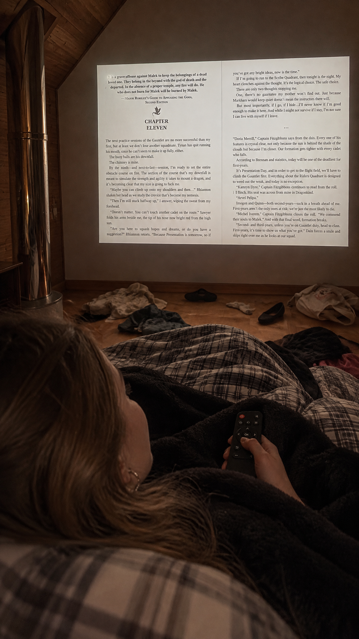 Lying in bed looking down the room at a page projected on the far wall, remote in hand