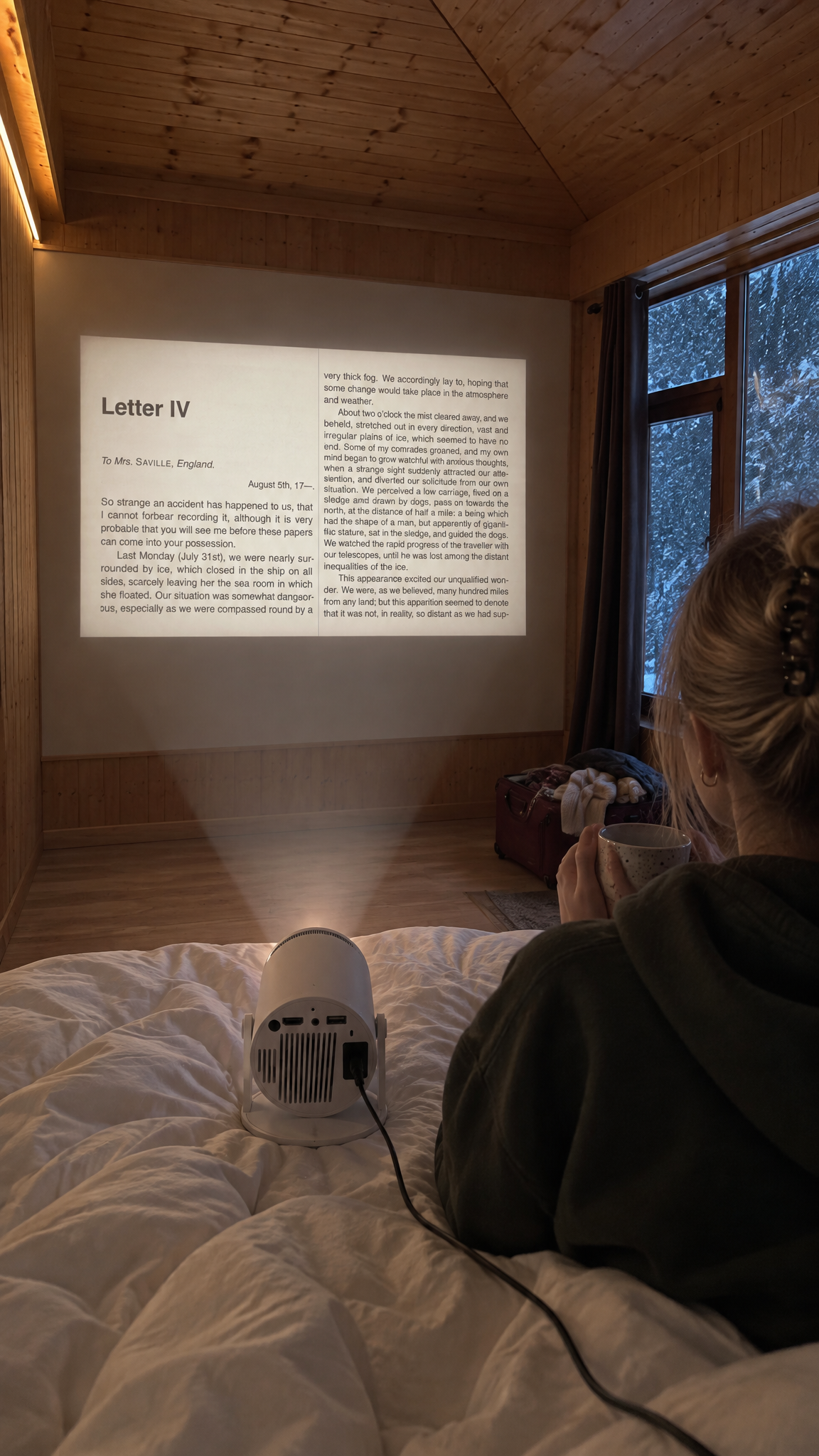 In a snowed-in cabin, the projector plugged in on the duvet throwing a page on the plank wall