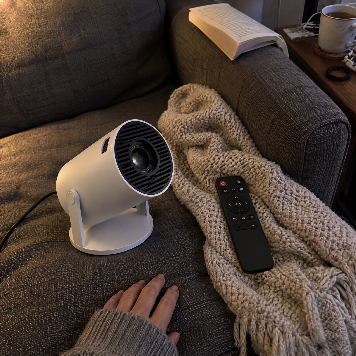 The projector switched off on a sofa cushion beside its remote, a customer's phone photo